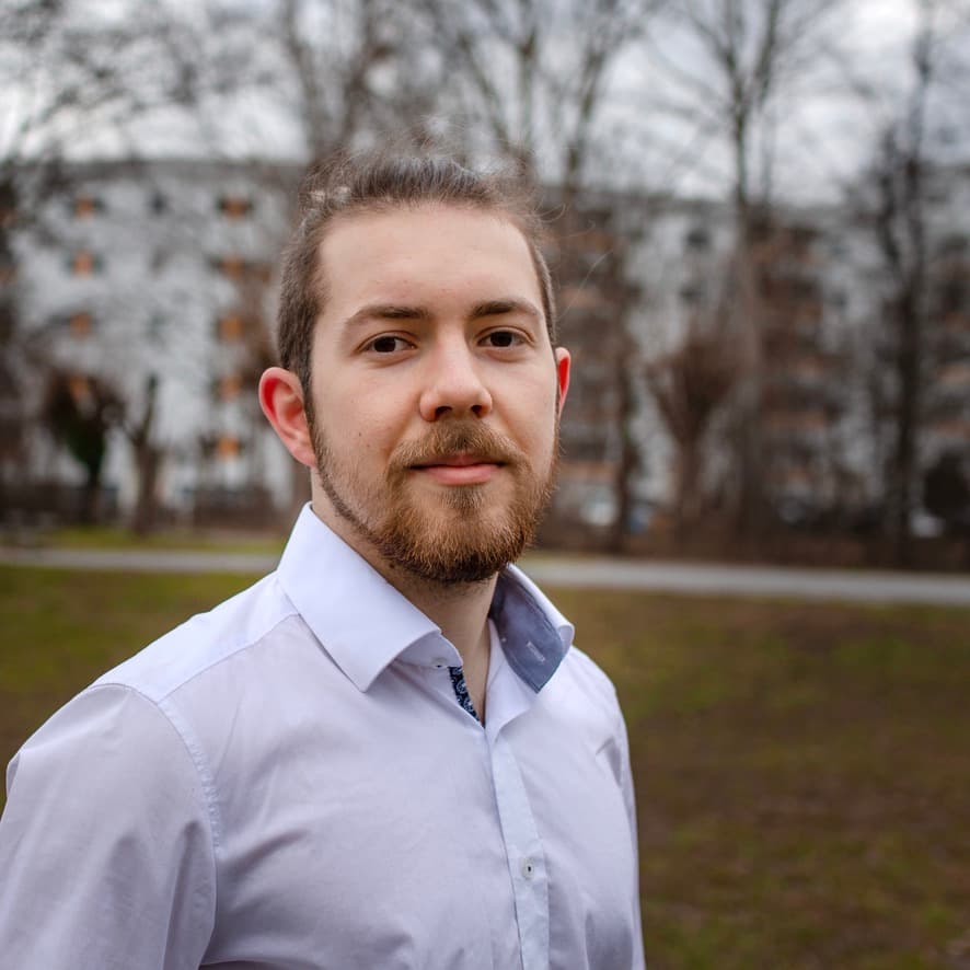 Foto von Jan Sprenger. Im Hintergrund ist eine urbane Herbstlandschaft.